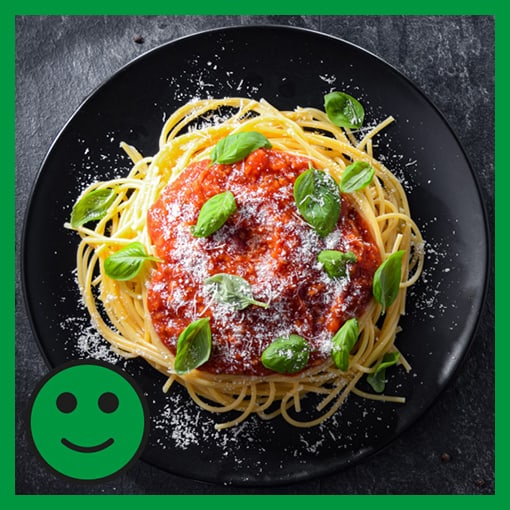 Ein Teller Spaghetti Bolognese mit einem grünen glücklichen Smiley